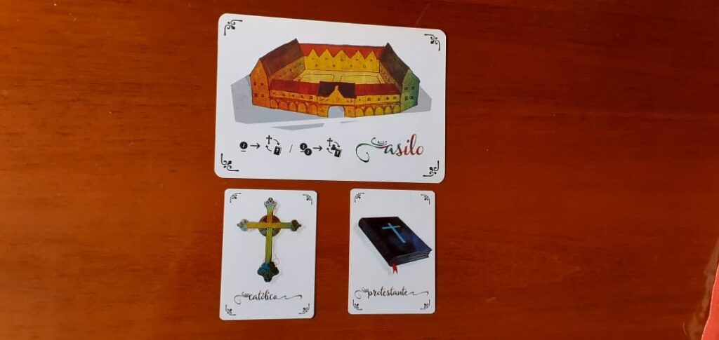 Cartas da expansão A Reforma, do jogo Coup. Asilo, Católico e Protestante.